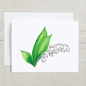 May include: A white card with a hand-drawn illustration of a lily of the valley flower with green leaves. The flower is in black ink and the leaves are in green watercolor.