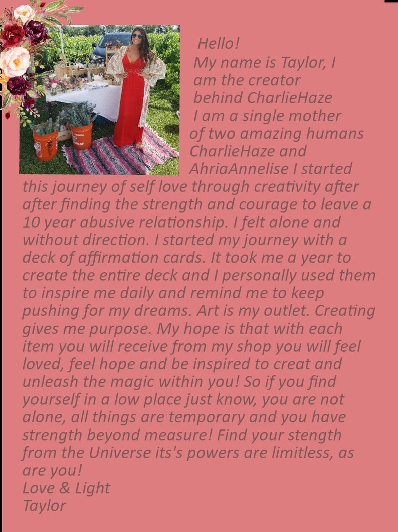 May include: A woman in a red dress stands in front of a table with a sign that reads "Charlie Haze". The text on the sign is a quote about self-love and creativity. The woman is smiling and holding a bouquet of flowers.