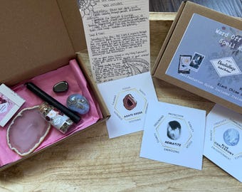 May include: A cardboard box containing a black chime candle, a small glass vial with dried herbs, a pink agate slice, a blue chalcedony stone, and a hematite stone. Includes three informational cards detailing agate, hematite, and blue chalcedony.