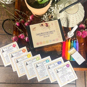 May include: A set of seven chakra meditation candles with matching cards. The candles are arranged in a rainbow order, with the root chakra candle at the top and the crown chakra candle at the bottom. The cards are labelled with the name of each chakra and include information about the chakra's colour, element, and associated crystals.