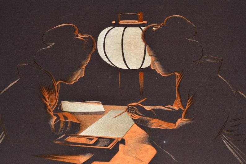 May include: Two women in traditional Japanese clothing sit at a table beneath a paper lantern, writing on a sheet of paper. The scene is depicted in a dark, stylised illustration.