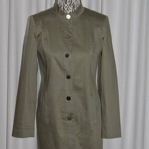 May include: A long-sleeved, olive green jacket with a mandarin collar and button closure. The jacket has a slim fit and is lined with a white fabric.