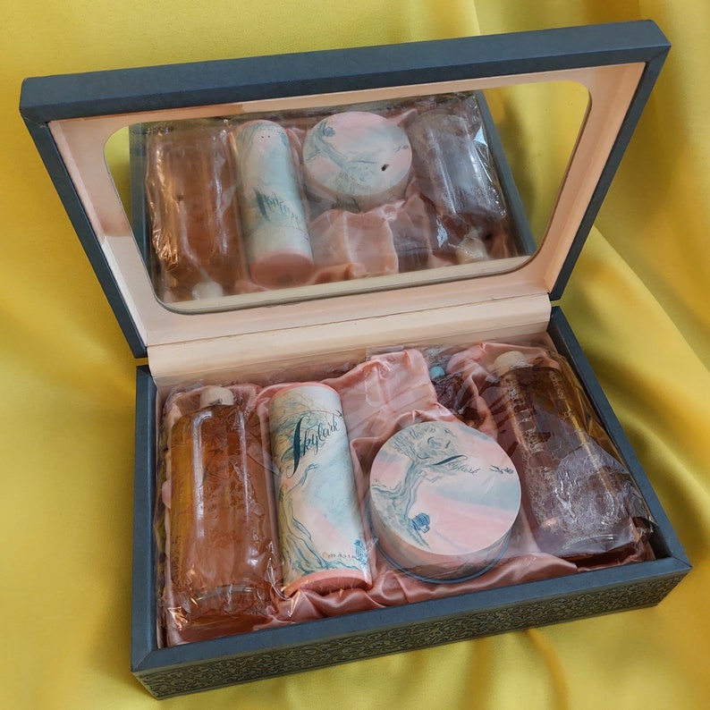 Pu&ograve; includere: Una scatola di legno con un coperchio a specchio, contenente un set di articoli da toeletta. La scatola &egrave; foderata in raso rosa e contiene un flacone di profumo, un flacone di colonia, un barattolo di cipria per il viso e un tubo di crema per le mani. Tutti i prodotti sono etichettati con la parola "Nightfall".