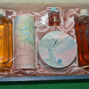 Pu&ograve; includere: Un set di flaconi di profumo vintage e una confezione compatta in una scatola rosa e bianca. I flaconi sono in vetro trasparente con dettagli dorati e la confezione compatta &egrave; rotonda con un design floreale. La scatola &egrave; rivestita in raso rosa.