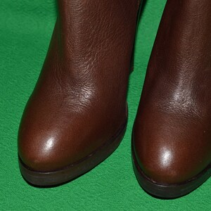 May include: A pair of brown leather ankle boots with a rounded toe and a low heel.