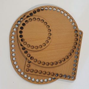 Peut inclure: Plusieurs fonds de paniers en bois non finis de différentes formes : un cercle, un carré et un ovale plus grand. Chaque base comporte des trous espacés régulièrement sur le pourtour pour attacher du fil ou d'autres matériaux. Le bois est de couleur claire.