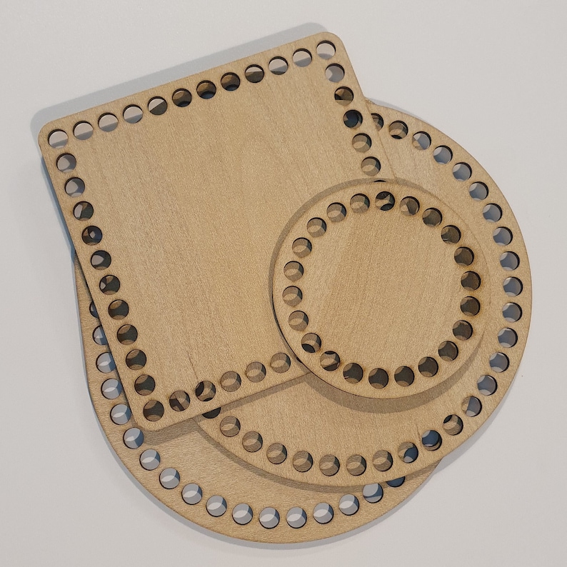 May include: Three wooden crochet hoops in different sizes, a square and two circles. The hoops are made of natural wood and have holes around the edges for crocheting.