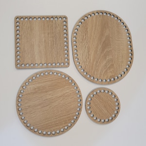 Puede incluir: Cuatro tablas de tejido de telar de madera en diferentes formas y tama&ntilde;os. Las tablas son de madera marr&oacute;n claro y tienen un patr&oacute;n circular de agujeros alrededor de los bordes.