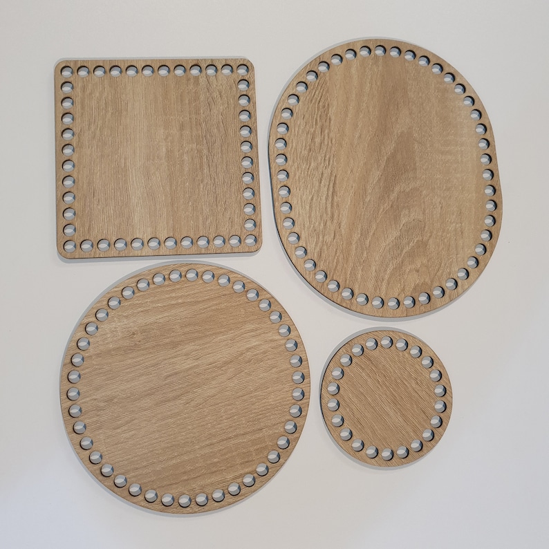 Puede incluir: Cuatro tablas de tejido de telar de madera en diferentes formas y tama&ntilde;os. Las tablas son de madera marr&oacute;n claro y tienen un patr&oacute;n circular de agujeros alrededor de los bordes.