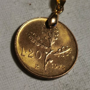 May include: A gold-colored coin pendant with an oak leaf design and the text "L.20" and "1975".