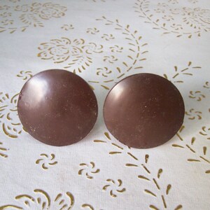 以下が含まれることがあります： 茶色の丸い装飾的なカーテン留めが2つ