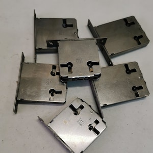 May include: Six silver metal door lock plates with keyholes and the text "BRIX" and "CHS" on them.