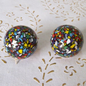 May include: A pair of colorful, round earrings with a confetti-like pattern. The earrings are made of black, white, red, yellow, blue, green, and purple.