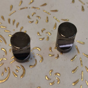 Peut inclure: Deux boutons ronds noirs pour armoire avec une finition brillante.