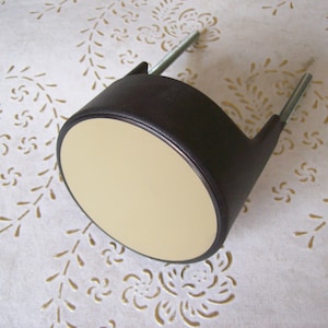 May include: A black and beige round ceiling light fixture with two metal rods.