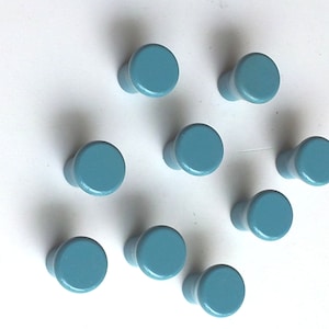 Puede incluir: Diez pomos de madera azules con la parte superior redonda y la base cilíndrica.