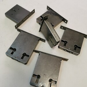 May include: Five silver-toned door lock plates with keyholes and the text "BREV. CAS." on two of the plates.