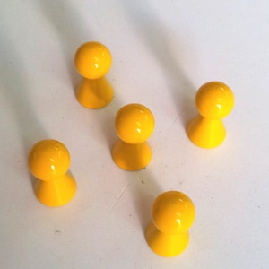 Könnte beinhalten: Fünf gelbe Spielfiguren in Form einer Person mit einem runden Kopf und einem kegelförmigen Körper.