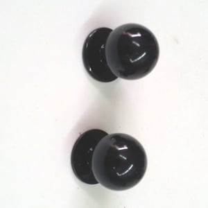 Puede incluir: Dos pomos redondos negros para armario con acabado brillante.