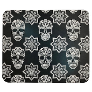 Può includere: Tappetino per mouse nero e bianco con un motivo ripetitivo di teschi stilizzati ed elementi floreali.