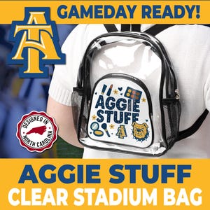 May include: Clear stadium backpack with black trim and mesh side pockets. The front features a white panel with the text "AGGIE STUFF" and a bulldog graphic. The bag is designed in North Carolina.