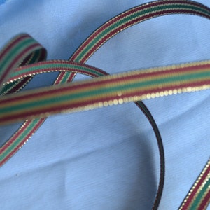 May include: Red, green and gold striped ribbon with a gold glitter finish.