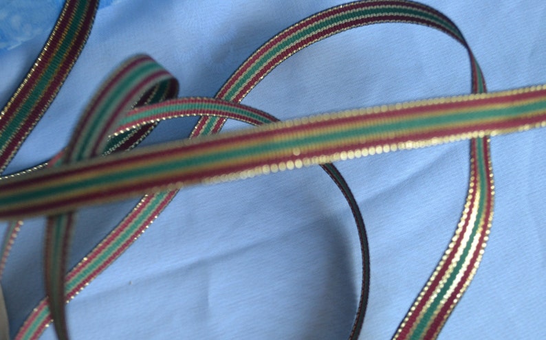 May include: Red, green and gold striped ribbon with a gold glitter finish.