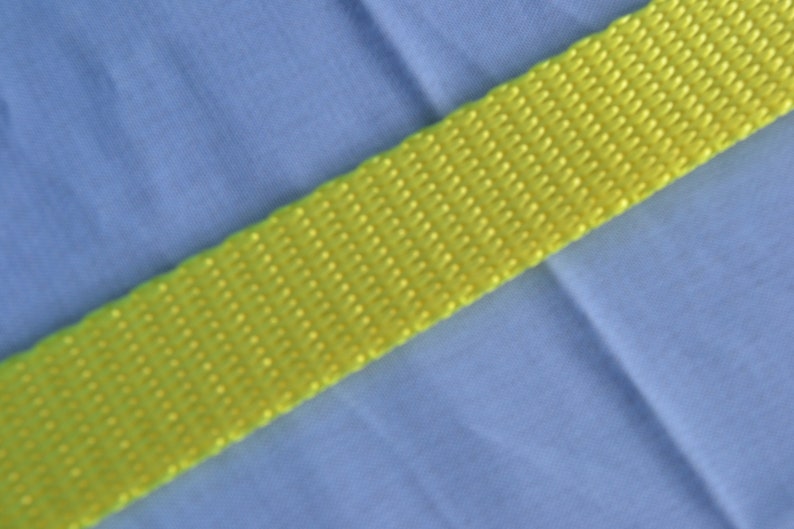May include: A bright yellow webbing strap with a textured surface.