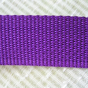 May include: Close-up of a purple woven strap with a textured diamond pattern.
