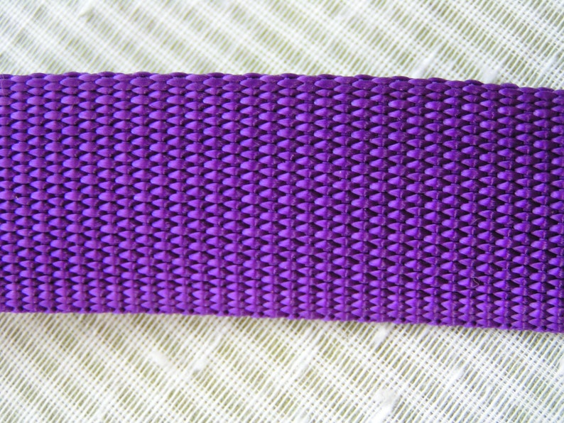 May include: Close-up of a purple woven strap with a textured diamond pattern.
