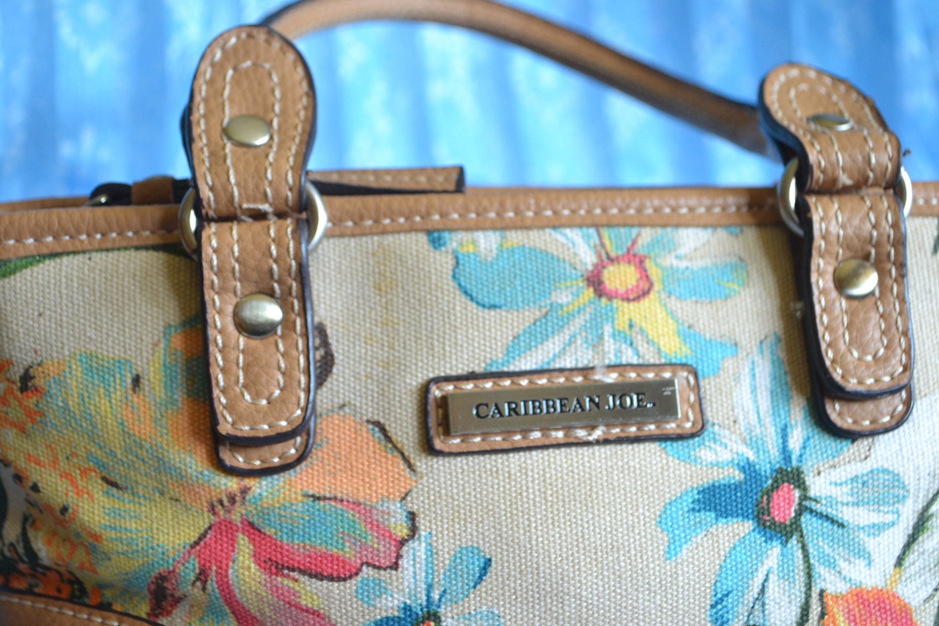 corners Floral fabric with tan faux leather on bottom top edge and double handles. Caribbean Joe handbag
