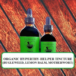 May include: Two glass bottles of organic tincture with dark liquid and dropper tops. The bottles have green labels with the text "BOSS" inside a heart-shaped design. The text "Organic Hyperthy-Helper Tincture" is also visible.