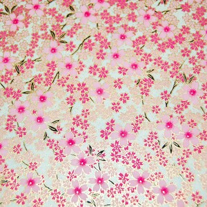 May include: A white background with a pink and gold floral pattern. The pattern is made up of small pink flowers with gold centers and gold leaves.