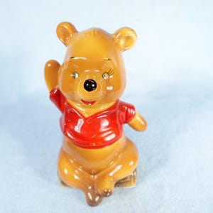 Producciones clásicas de Walt Disney: Winnie Pooh sentado en un tronco