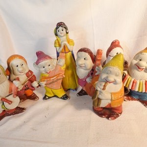 以下が含まれることがあります： 白雪姫と7人の小人から、7人の小人のセラミック製フィギュアのセット。それぞれ異なる楽器を演奏しています。白雪姫もセットに含まれており、中央に立っています。