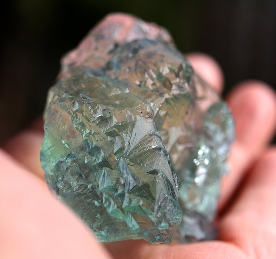 A gemmy completely translucent etched Fluorite. Fujian Province, China. Green with violet hues. Glows in light. 2.5 by 2.5 inch. 202 gram