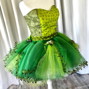 tinkerbell corset dress Tinkerdust A fairytale blend of Tinkerbell and Pixie Dust inspirations shimmering shades of green with golden accents, made to sparkle this Halloween. Message us now to RENT your