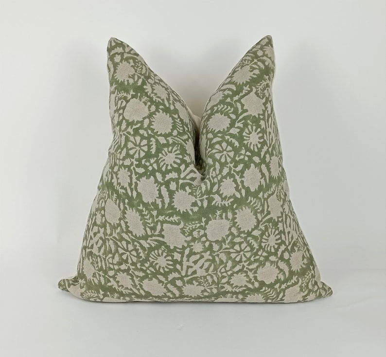May include: A green and white floral patterned pillow cover. The pillow cover is made of a soft, linen fabric.