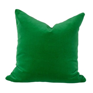 May include: A solid green velvet pillow with a square shape.