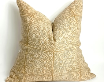 May include: A tan throw pillow with a white geometric pattern. The pillow is made of a soft, textured fabric.