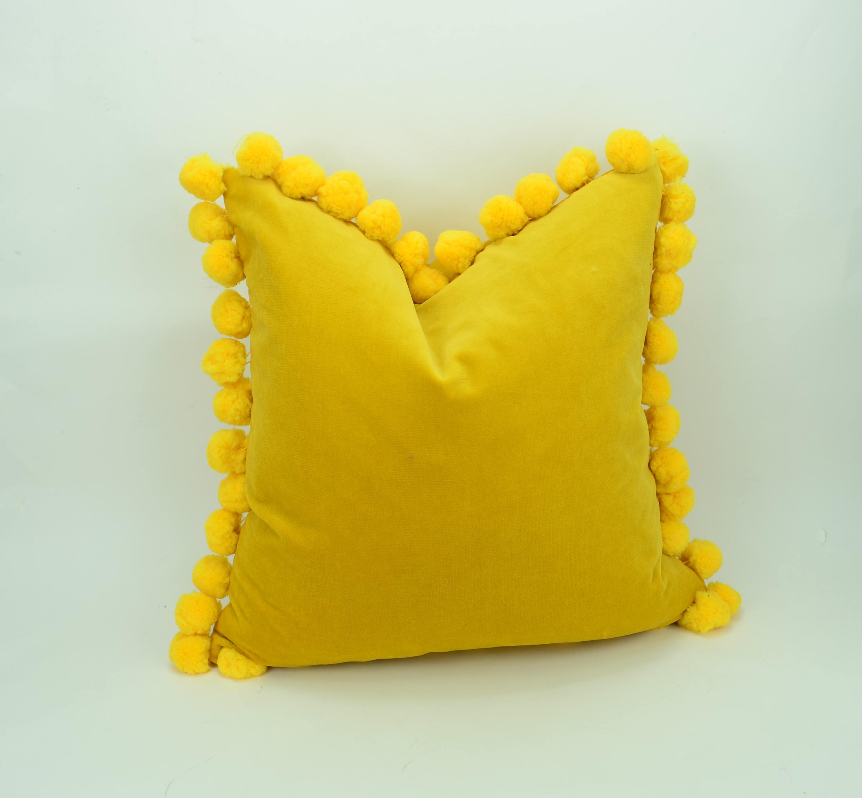 yellow pom pom pillow