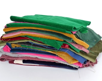 Könnte beinhalten: Ein Stapel rechteckiger Stoffreste in verschiedenen Farben, darunter leuchtendes Grün, Senfgelb, Pink, Olivgrün, Marineblau, Grau und Burgunderrot. Die Stücke bestehen aus weichem Samt mit kurzem Flor und sichtbaren losen Fäden an den Rändern.