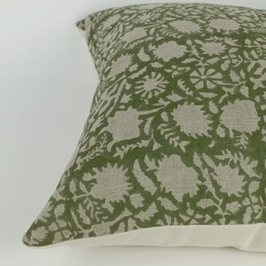 May include: A green and white patterned throw pillow with a floral design. The pillow is made of a soft, linen-like fabric.