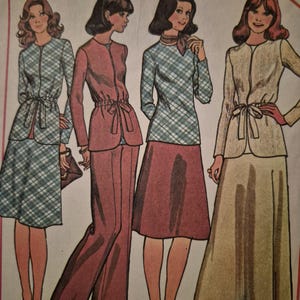 May include: A vintage sewing pattern illustration featuring four outfits with jackets, skirts, and trousers. The designs include a plaid jacket with a matching skirt, a solid mauve jacket with trousers, a plaid top with a solid skirt, and a beige jacket with a long skirt.