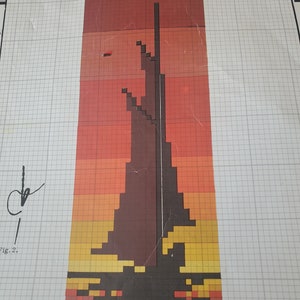 May include: A vintage cross-stitch pattern chart featuring a stylized, pixelated design of a tower or structure against a sunset gradient of red, orange, and yellow. The chart includes color codes and the text "ANKER nr." and "Fig. 2."