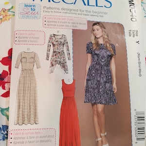 Pode incluir: Um padrão de costura para um vestido com três estilos diferentes. O padrão é para iniciantes e inclui instruções sobre como costurar com listras, franzir o tecido e estreitar as bainhas. O padrão chama-se McCall's M0540 e é para o tamanho Y (Xsm-Sml-Med).