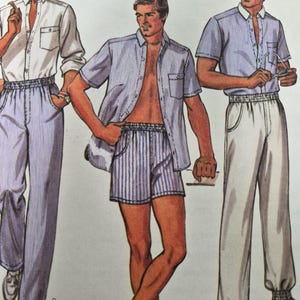 May include: A sewing pattern illustration featuring three outfits. One shows a white long-sleeve shirt with blue striped trousers. Another shows a blue striped short-sleeve shirt with matching shorts. The third shows a blue striped shirt with white trousers.