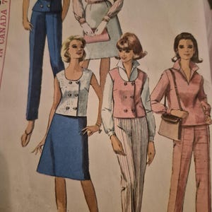 May include: A vintage sewing pattern envelope featuring illustrations of various outfits including a blue double-breasted vest and skirt, a pink vest with striped trousers, a long-sleeved pink pant suit, and a blouse with a skirt. Text includes J. M. Bostwick & Sons.