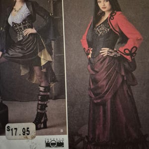 May include: A sewing pattern envelope featuring two costume designs. The left shows a black jacket, white lace top, and skirt. The right shows a red jacket with black trim, a black lace corset, and a long, dark red skirt with a ruffled hem and top hat.