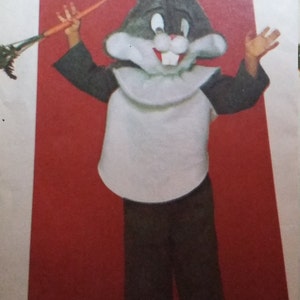 May include: A Bugs Bunny costume pattern. The costume includes a Bugs Bunny head, white bib, dark gray sleeves, and dark brown pants. The Looney Tunes logo is visible.